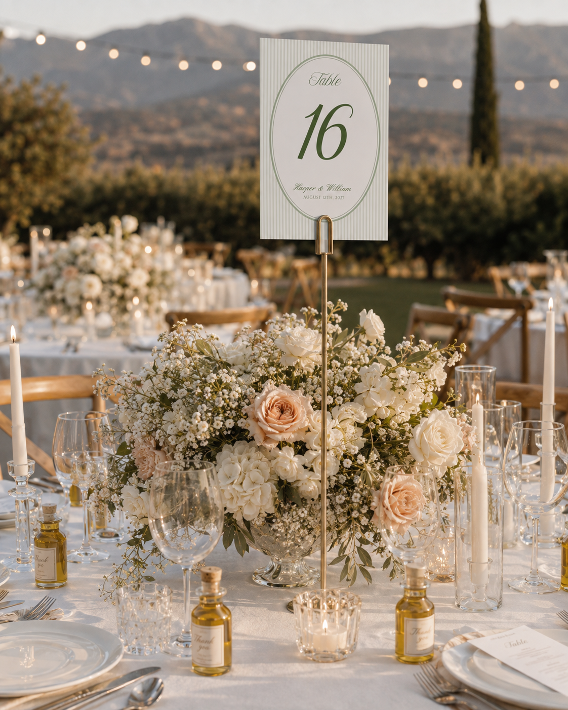 Sage green oval table sixteen sign above a flower-filled wedding reception table