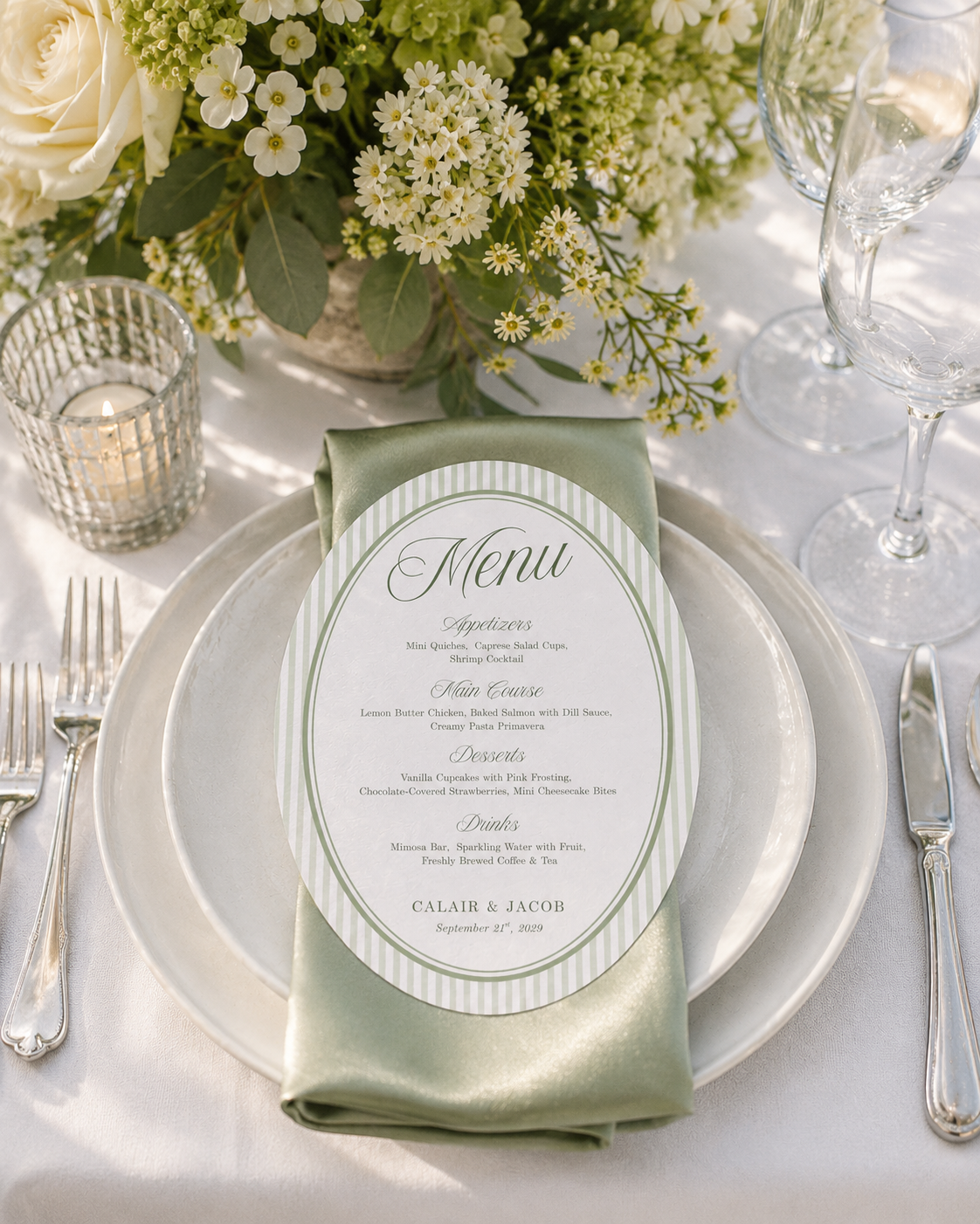 Sage striped oval wedding menu on a folded green napkin and white dinner plate